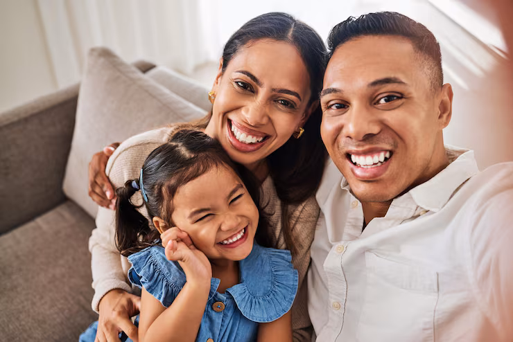 Família de imigrantes brasileiros sorrindo, protegida pelo seguro de vida com benefício em vida da Forte Financial